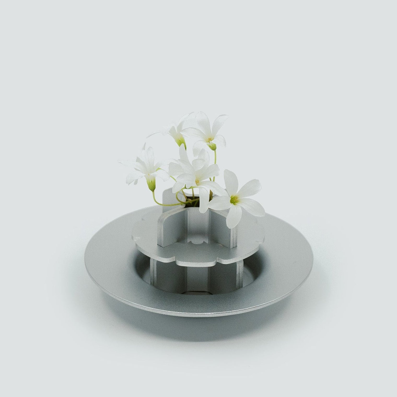 Metallic bud vase, flower arrangement on a white background